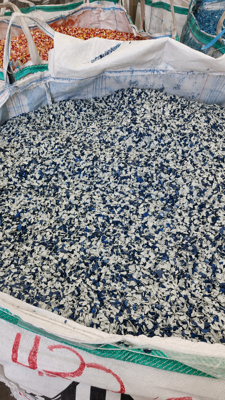 Hojuelas recicladas azules y blancas en contenedor industrial